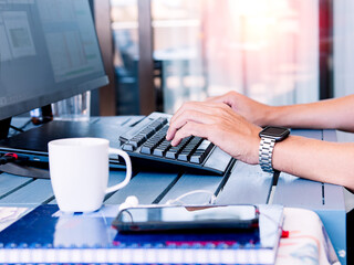 Casual workspace with coffee and tech devices on sunny desk