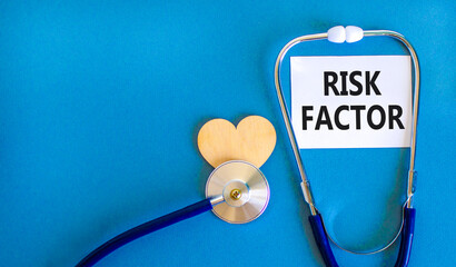 Risk factor symbol. Concept words Risk factor on beautiful white card. Wooden heart and...
