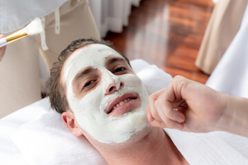 Serene ambiance of spa salon, man customer indulges in rejuvenating with luxurious face cream...