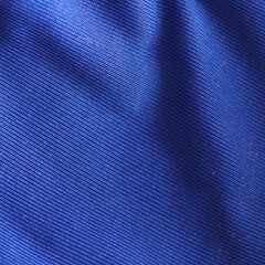 Blue textile fabric texture with diagonal lines and folds