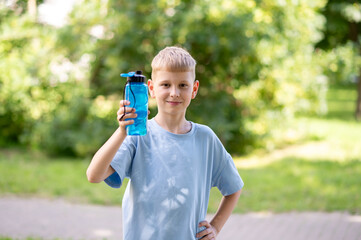 Smiling boy holding water bottle outdoors on a sunny day