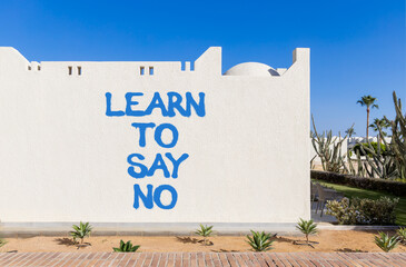 Learn to say no symbol. Concept words phrase Learn to say no on beautiful white wall. Beautiful white wall and blue sky background. Business psychological Learn to say no concept. Copy space.