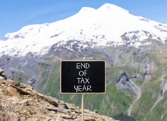 End of tax year symbol. Concept words phrase End of tax year on beautiful black blackboard. Beautiful mountain Elbrus background. Business End of tax year concept. Copy space.
