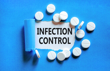 Infection control symbol. Concept words Infection control on beautiful white paper. White pills tablets. Beautiful blue background. Medical healthy lifestyle infection control concept.