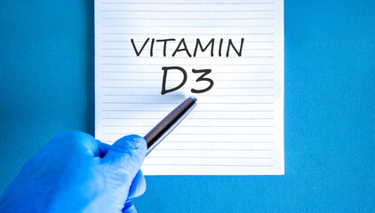 Vitamin D3 symbol. Concept words Vitamin D3 on beautiful white note. Doctor's hand in blue medical glove. Black pen. Beautiful blue background. Medical healthy lifestyle Vitamin D3 concept.