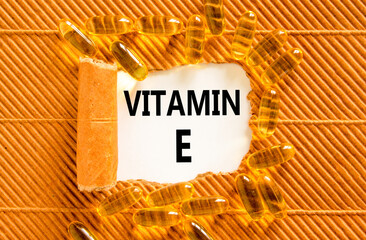 Vitamin E tocopherols symbol. Concept words Vitamin E on beautiful white paper. Yellow pills tablets. Beautiful brown background. Medical healthy lifestyle Vitamin E tocopherols concept.