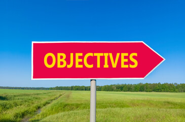 Objectives symbol. Concept word Objectives on beautiful red road sign. Beautiful blue sky green grass and forest peaceful nature background. Business objectives concept. Copy space.