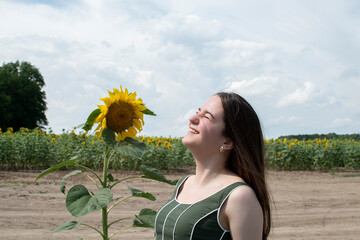 A young attractive woman sitting  near sunflower