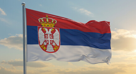 The Serbian flag flowing with the early morning breeze, proudly waving under a clear sky.