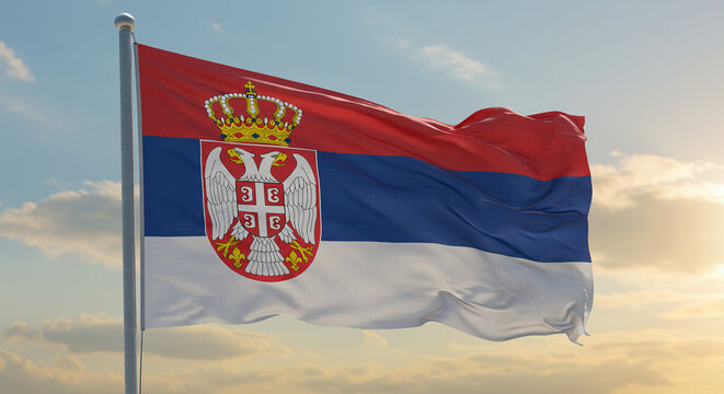 The Serbian flag flowing with the early morning breeze, proudly waving under a clear sky.