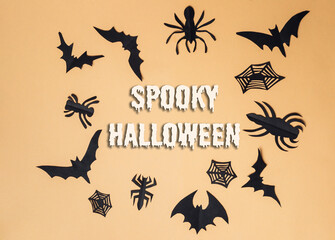 Spooky Halloween decorations featuring black bats, spiders, and cobwebs on a warm backdrop
