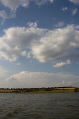 A body of water with clouds in the sky