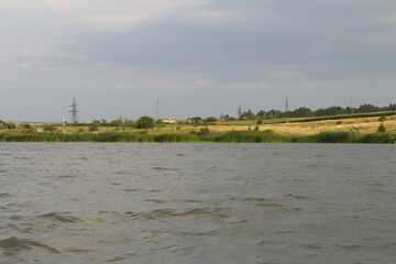 A body of water with a grassy hill in the background