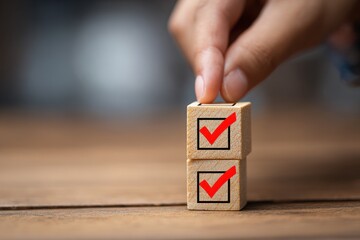 Hand Placing Red Tick on Wooden Cube for Checklist Completion or To-Do List Accomplishment
