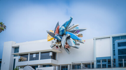 A piece of art of Boats hanging from a house