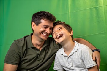 Portrait of happy father and son on sofa at home