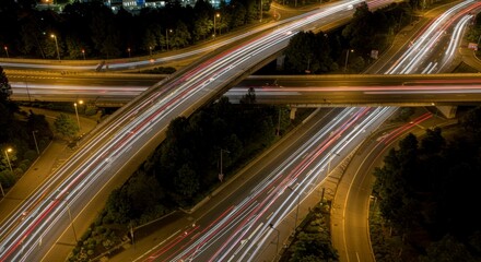 Nighttime highway interchange, showing streaks of light from moving vehicles