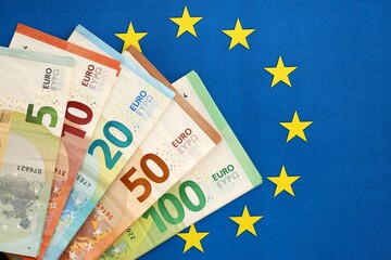 European eur currency money bills on Euro union blue flag close up