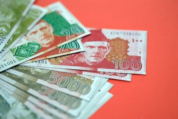 Pakistan rupees banknotes on red background. The current Pakistan money bills