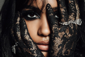 Fashion model wearing black lace gloves and diamond rings	