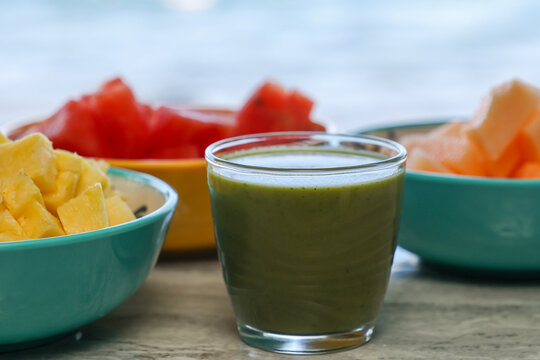Colorful Tropical Fruit Green Smoothie with Fresh Pineapple, Watermelon, and Cantaloupe in Summer Setting