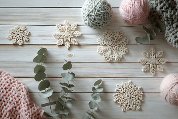 Cozy winter flat lay with decorative snowflakes, soft yarn, and eucalyptus branches on a rustic wooden background.