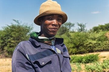 africa village, portrait of young african man , outdoors against the blue sky, bush in the backgrounds