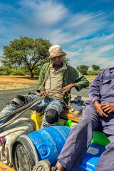 donkey cart on the road, africa water shortage, people carry water between villages with plastic containers
