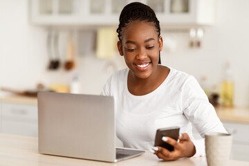 Business And Telecommuting Concept. Portrait of smiling young black woman using her smartphone and...