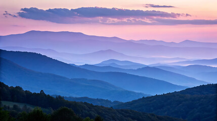 Obraz premium Layers of blue and purple mountains at sunset create a scenic vista