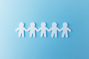 Paper cutouts symbolize unity and connection, set against a soft blue backdrop, highlighting teamwork and community.