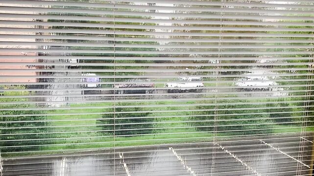 Downpour outside the window with blinds .Bad weather office