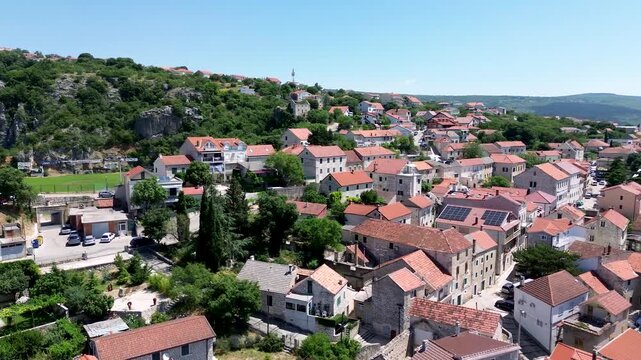 4K Aerial Drone Flight Over Imotski, Croatia, Revealing the Local Football Stadium Surrounded by Residential Buildings and Mountain Landscape