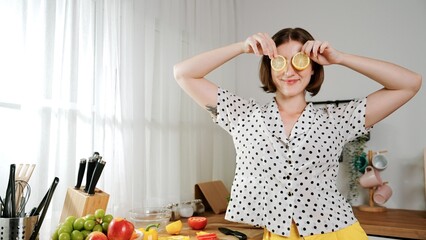 Happy mother chopping at vegetable or making salad and pose at camera. House keeper prepare fresh...