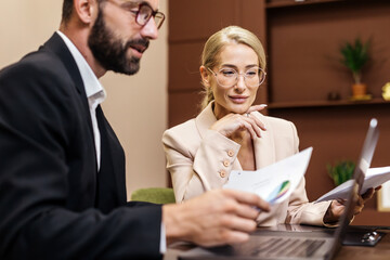Business professionals engaged in strategic planning discussion at modern office, analyzing...