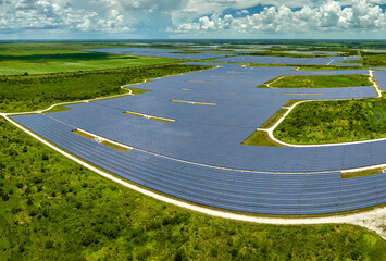Aerial view of big sustainable electric power plant with many rows of solar photovoltaic panels for...