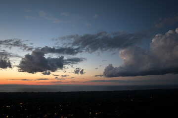 Amazing evening skyscape. Sunset sky with bright colorful clouds over dark landscape