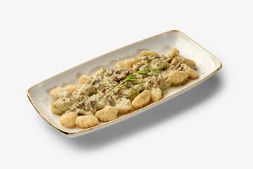 Potato gnocchi with creamy mushroom sauce served on a rectangular plate