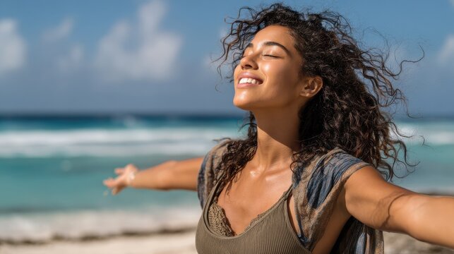 Smiling latin hispanic woman stretching hand and relaxing on beach. Woman breathing deeply at seaside with eyes closed. Happy woman standing on the beach and enjoy the sun tan with arms outstretched.
