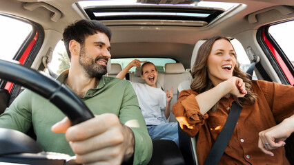 Finally, we are going on vacation. Happy family of three enjoying travelling by car, dancing to...