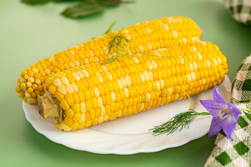 Appetizing corn on a plate with basil and dill
