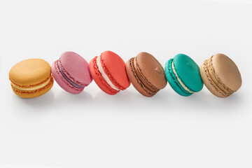 Colorful macarons forming a diagonal line on white background