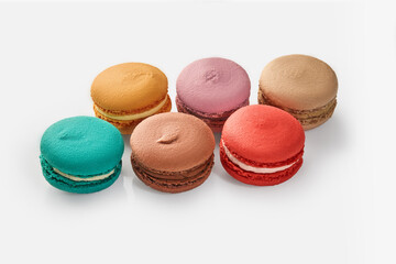 Six colorful macarons with various flavors on white background
