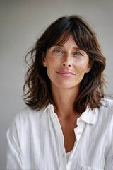 Fototapeta premium Captivating woman with glowing skin poses naturally against a neutral background