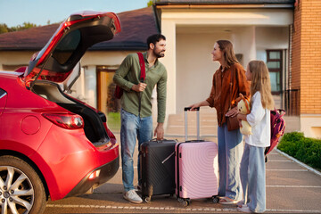 Family putting baggage suitcases in their car, relocating to new home or preparing for vacation,...