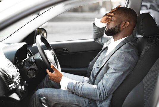 Bad day. Exhausted african american entrepreneur on a way home, driving car - Powered by Adobe