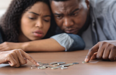 Family Financial Problems. Young Black Couple Counting Remaining Coins On Table, Suffering From...