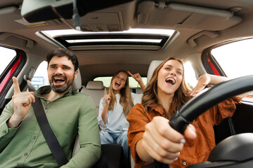 Happy European family of three riding car and singing, traveling by automobile, enjoying auto ride...