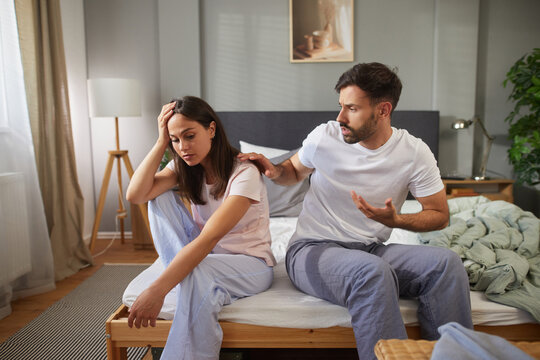 A couple experiences tension as they communicate about their relationship difficulties. The woman appears distressed, while the man gestures expressively, aiming to engage in the conversation.