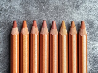 Set of six wooden pencils with various shades of lead. Organized in two rows on a textured surface.